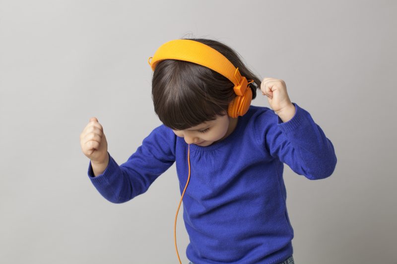 smiling infant with headphones focusing on rhythm and music