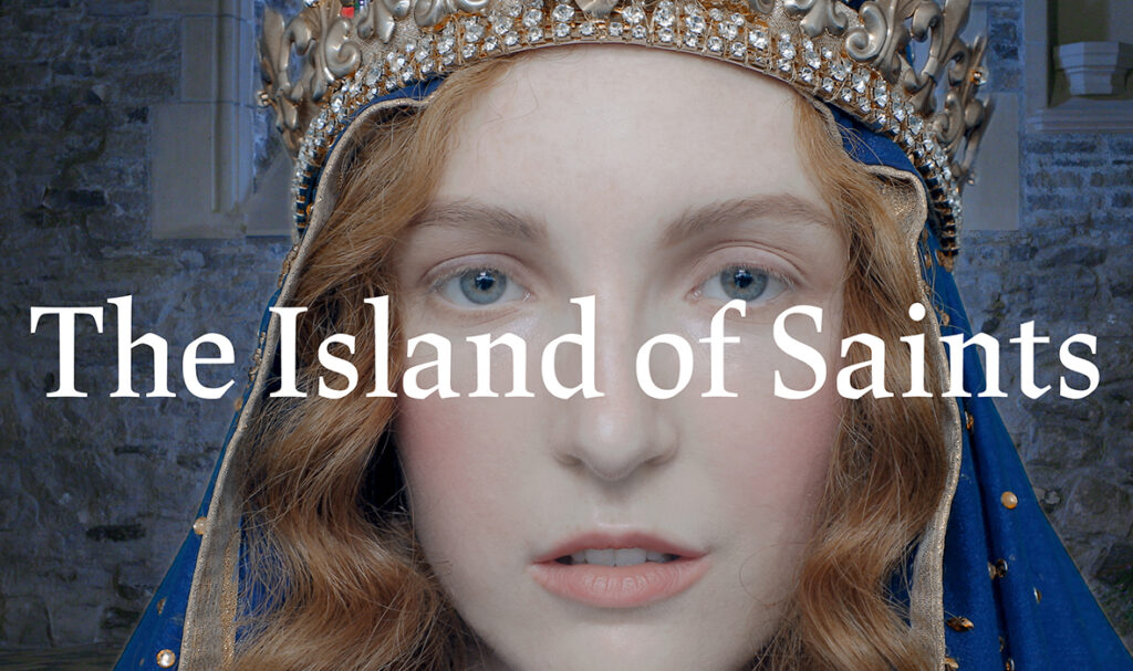 A close up of a pale, red-haired, blue-eyed woman's face. She is wearing a medieval blue and gold veil and a gold, diamond-rimmed crown. In the background is a grey stone wall, the interior of a castle. Across the image is the title "The Island of Saints."