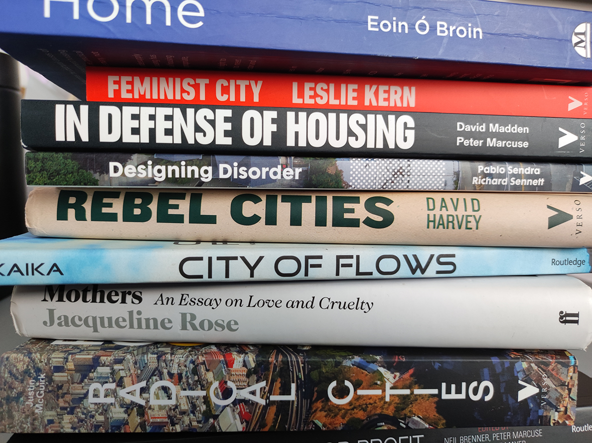 Photograph shows a stack of books resting on their sides with predominantly red green black and white colours used on their spines/designs. Visible titles include: Ground Control: Fear and happiness in the twenty-first-century city, Anna Minto Neoliberal Urban Policy and the Transformation of the City, Edited by Andres MacLaran and Sinéad Kelly Rent and its Discontents, Edited by Neil Gray The Heart of the Race: Black Women’s Lives in Britain, Beverley Bryan ,  Stella Dadzie , and  Suzanne Scafe Sins of the Father: Tracing the Decisions that Shaped the Irish Economy Spatial Justice and the Irish Crisis Urban Warfare, Raquel Rolnik