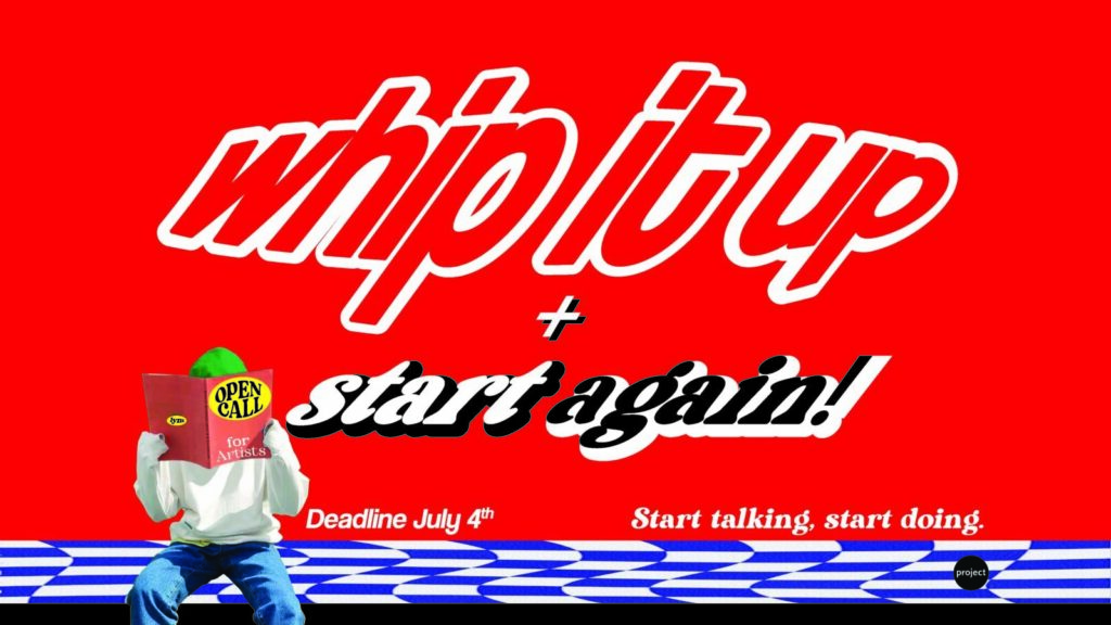 The billboard features a red background. In the corner of the image a person sits holding a booklet in front of them, covering their face. The front of the booklet reads "OPEN CALL for Artists", the person wears a green hat, a white jumper and blue jeans and sits on a blue and white chequered floor. The text on the billboard reads "Whip it up + start again, Deadline July 4th, Start talking, start doing. For more info visit projectartscentre.ie".